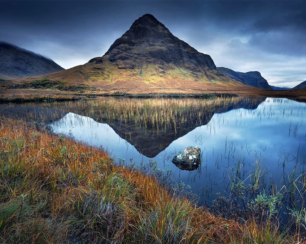 A mountain is reflected in a still pool in the highlands of Scotland