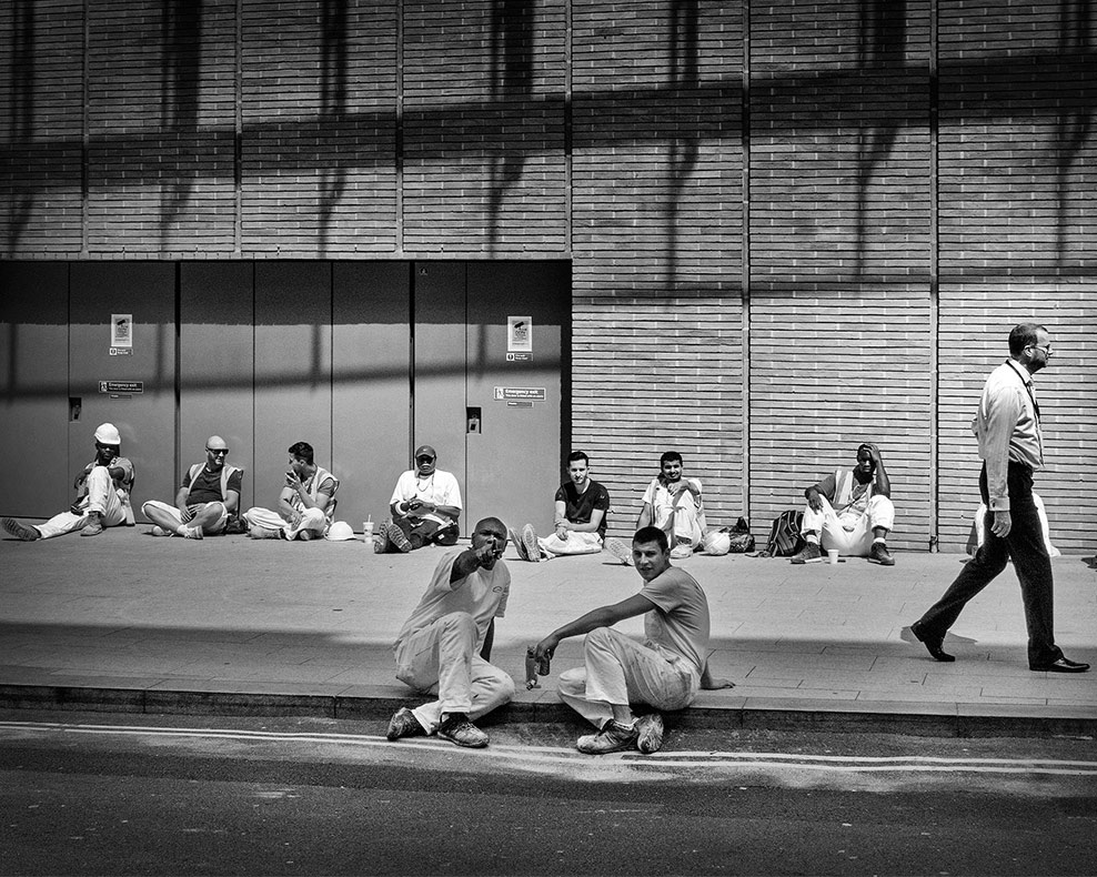 A black and white photograph of constuction workers during their lunch break
